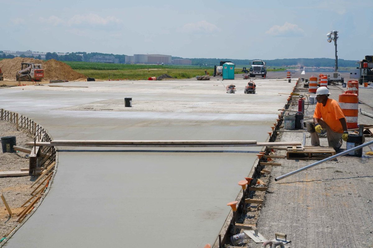 Neu aufgetragenes Betonpflaster und Ausrüstung für die Fertigstellung während der Startbahnreparatur